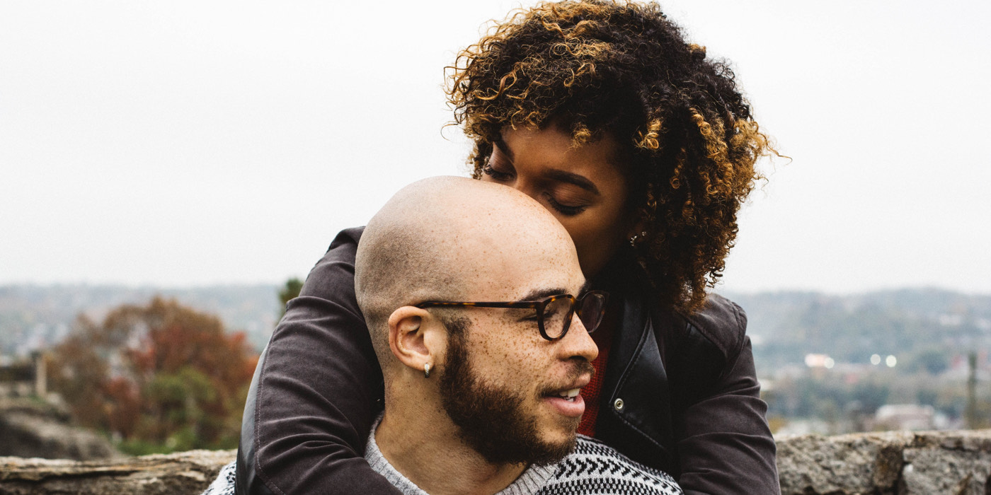 Couple embracing by rock wall